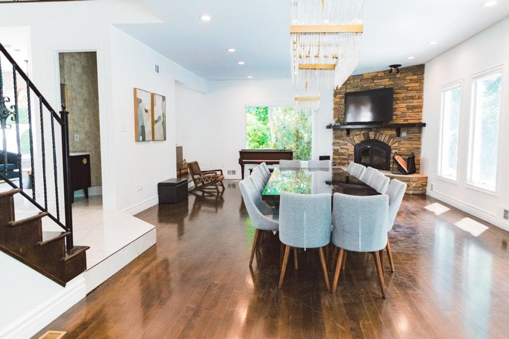 Open dining and living with crystal chandelier and stone fireplace
