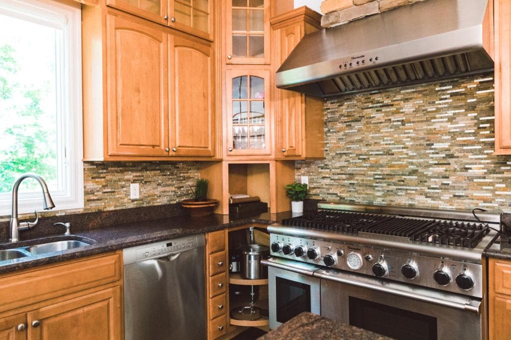 Chef-style kitchen with professional range and stone backsplash