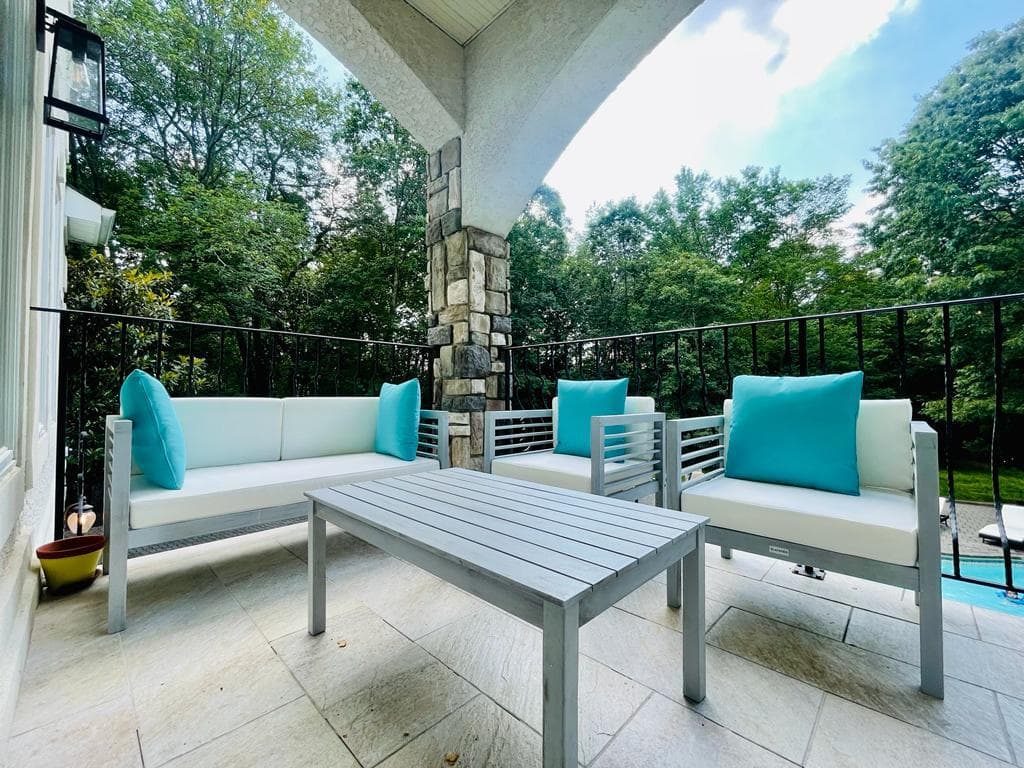 Upper patio lounge with stone arch and forest view
