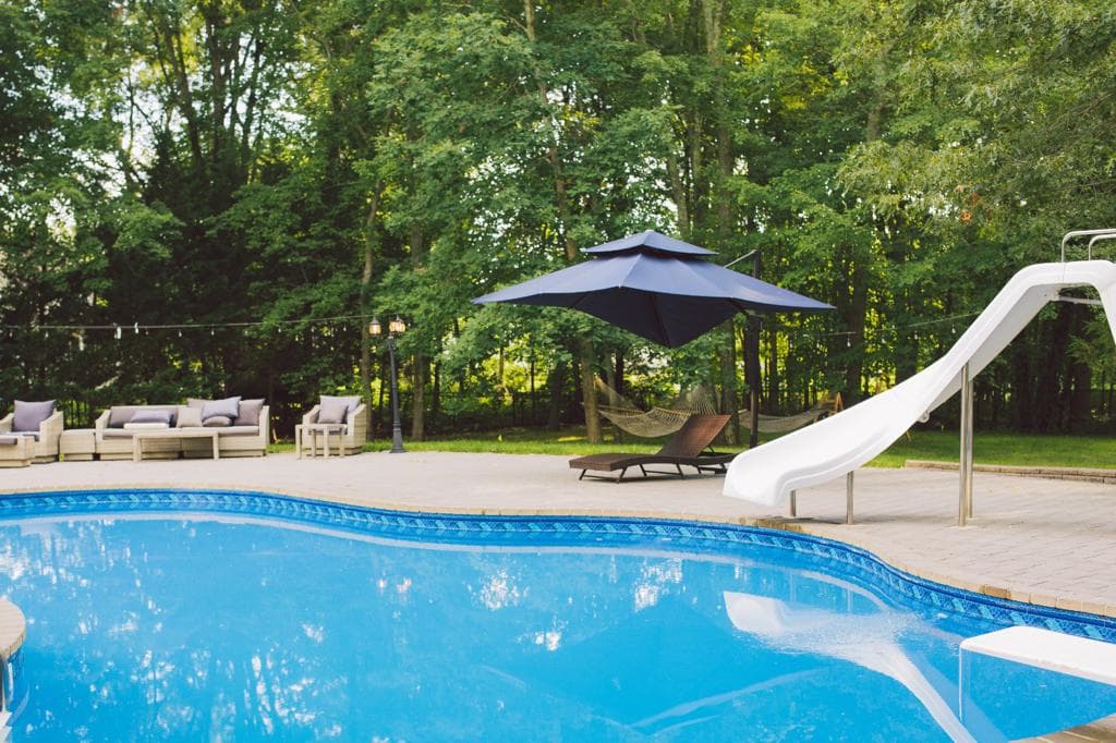 Pool, slide, and outdoor lounge with wicker seating