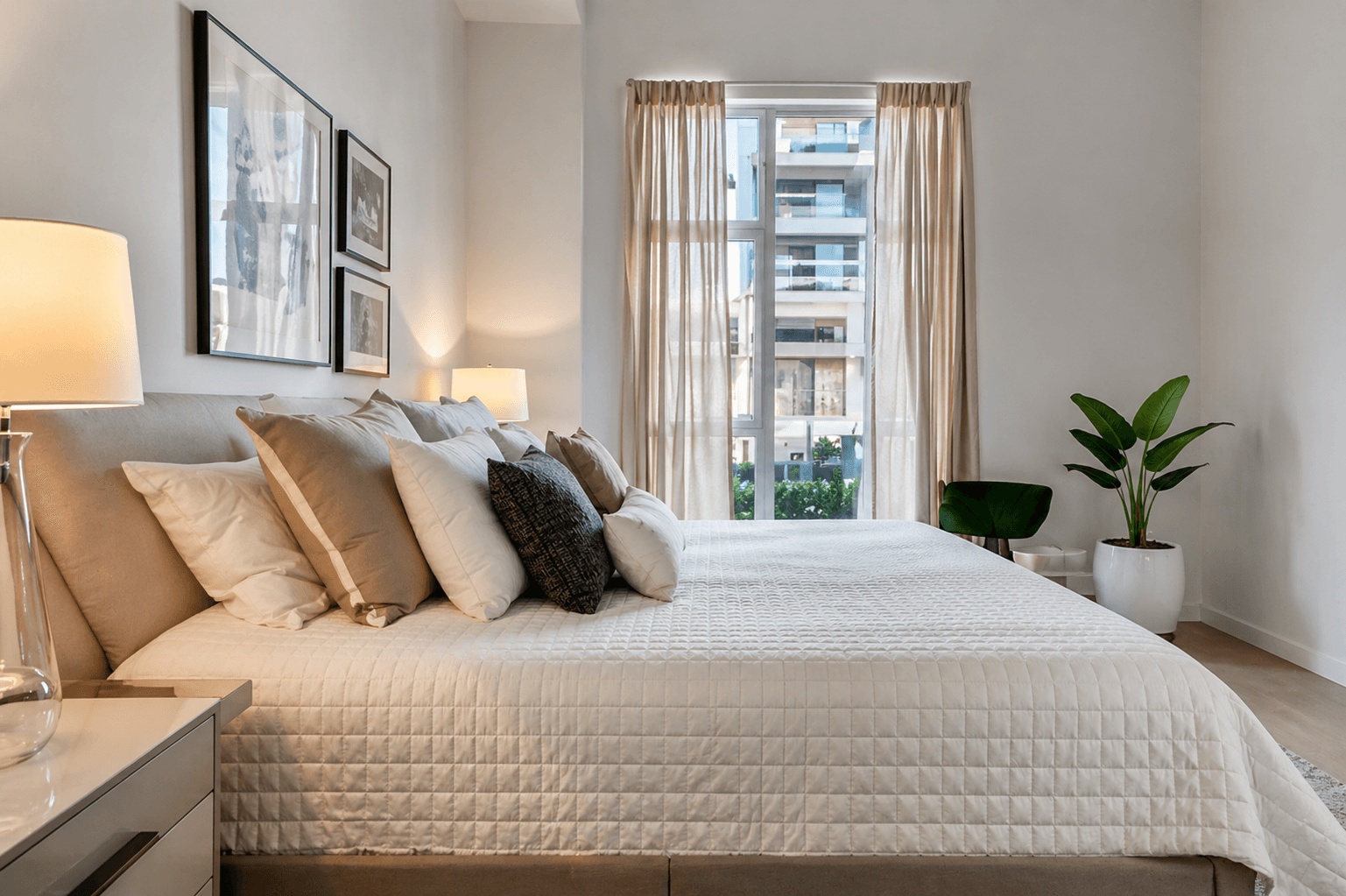 Master bedroom with neutral tones, framed art, and natural light at the Miami ocean front apartments
